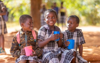 Children smiling with mugs
