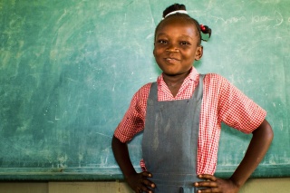 A girl stands in front of a chalkboard