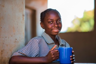 A girl with a mug of porridge