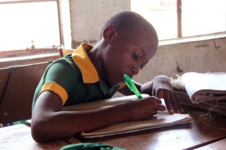 a child takes notes in class